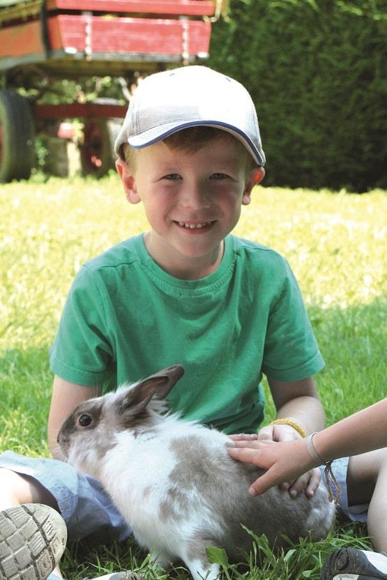 enfant a la ferme avec lapin