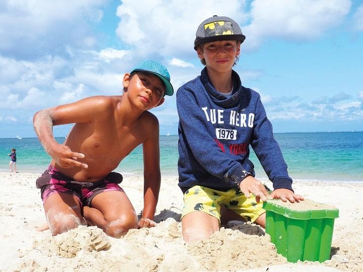Enfants qui jouent sur la plage avec le soleil