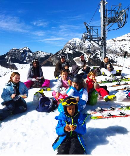 enfants en colo qui déjeunent sur les pistes de ski