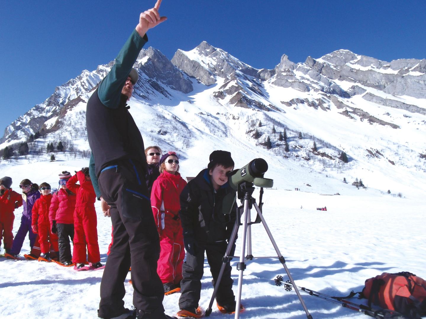 Groupe enfants en raquettes avec observation longue vue