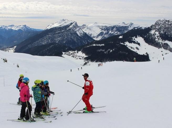 groupe d'enfants qui prennent des cours de ski