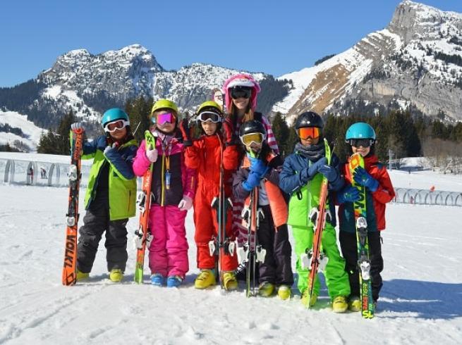 Groupe d'enfants qui sont sur les pistes de ski