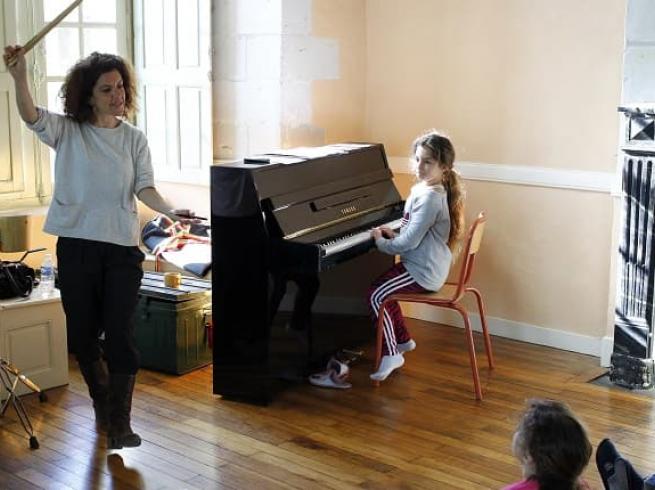 élève jouant du piano avec son professeur de musique