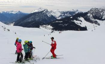groupe d'enfants qui prennent des cours de ski
