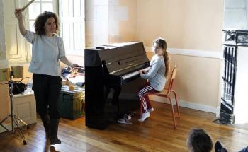 élève jouant du piano avec son professeur de musique
